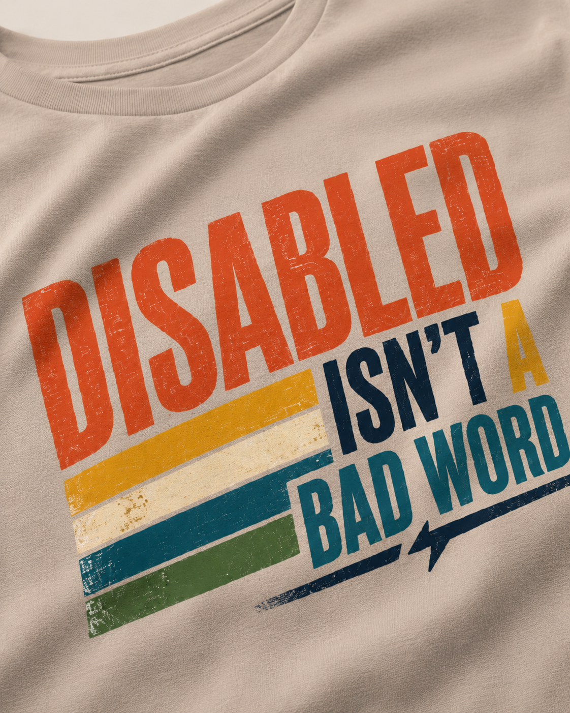 Beige t-shirt with colorful text 'DISABLED ISN'T A BAD WORD' on a beige background