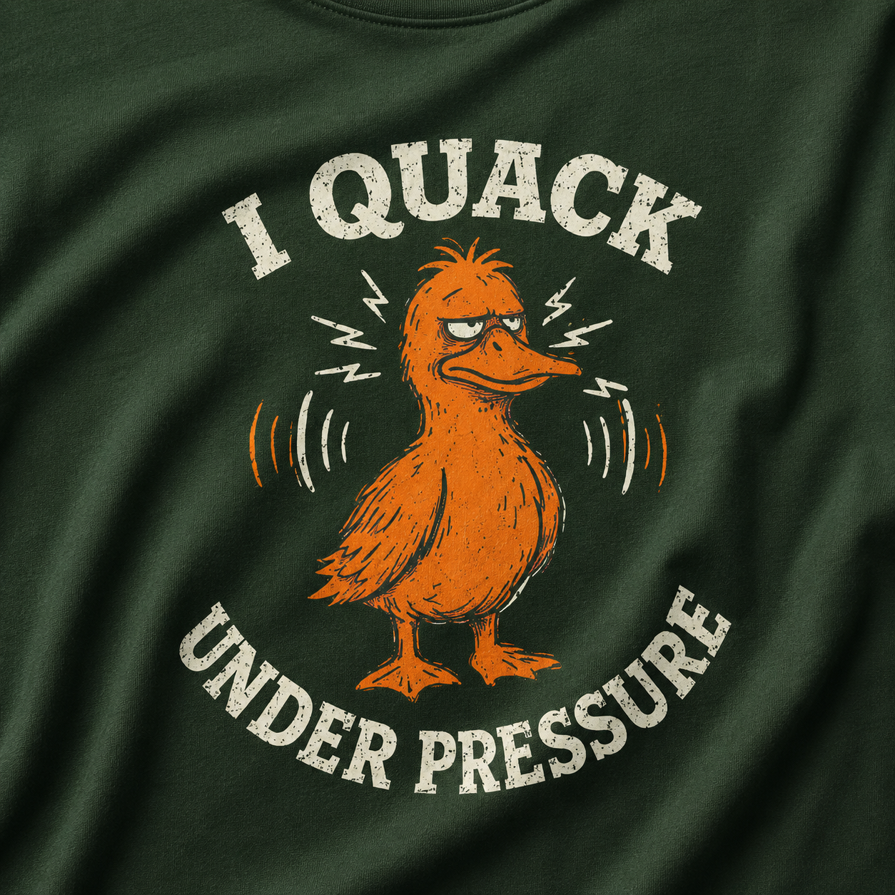 Green t-shirt with a cartoon duck and text 'I Quack Under Pressure' on a dark green fabric background.