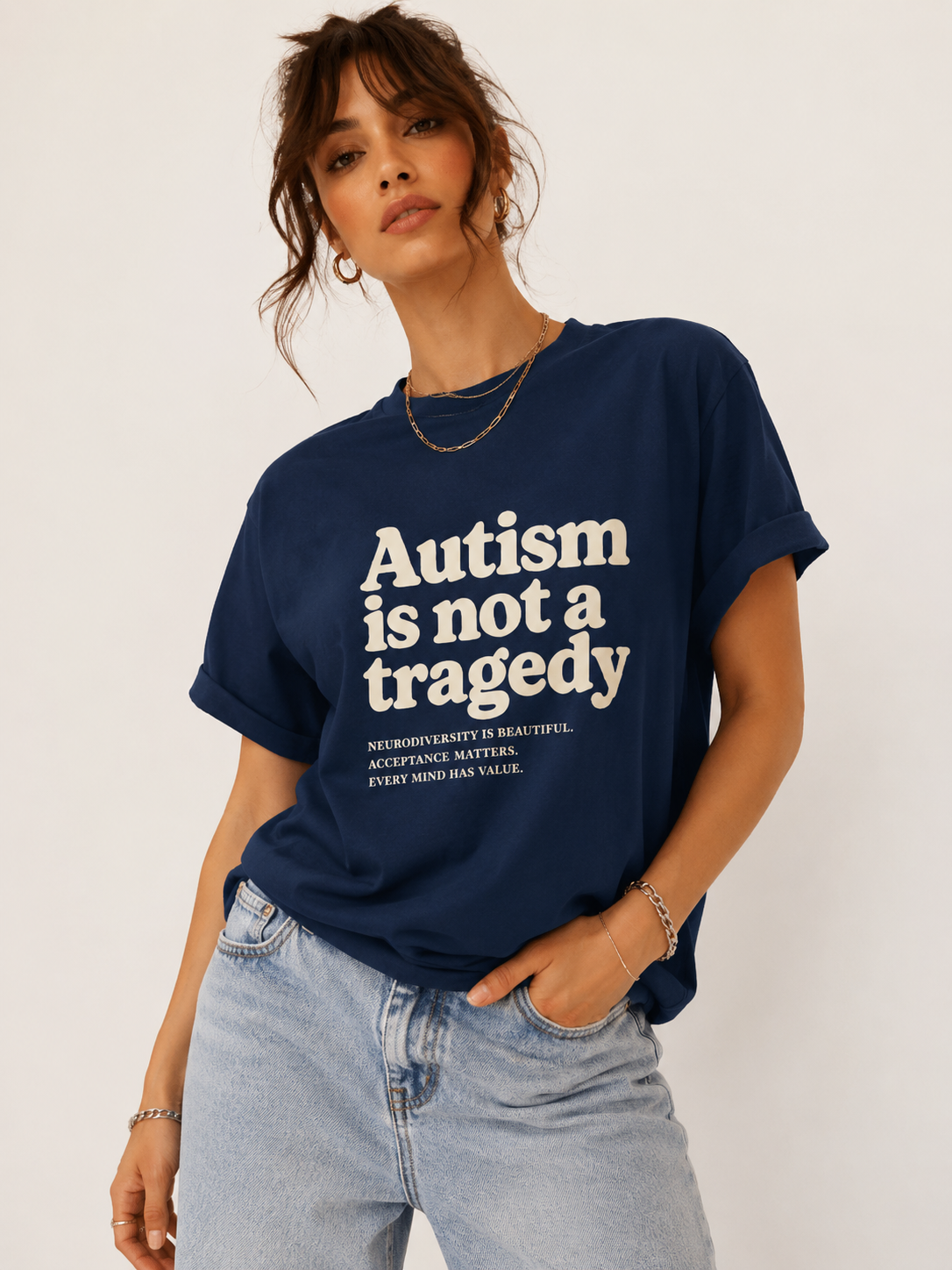 Person wearing a navy blue t-shirt with 'Autism is not a tragedy' text on a plain background